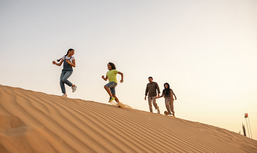 Sandboarding on the dunes in the morning desert safari