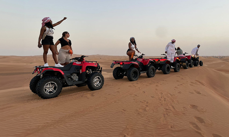 Guest riding Polaris 570cc quad over Dubai dunes